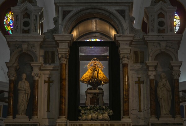 The original statue of the Virgin of Charity of El Cobre stands behind the altar at her shrine in El Cobre, Cuba, Sunday, Feb. 11, 2024. The Vatican-recognized Virgin, venerated by Catholics and followers of Afro-Cuban Santeria traditions, is at the heart of Cuban identity, uniting compatriots from the Communist-run Caribbean island to those who were exiled or emigrated to the U.S. (AP Photo/Ramon Espinosa)