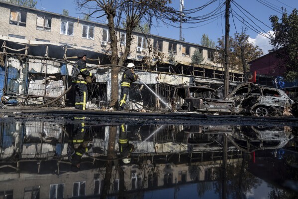 Rescue workers puts out a fire after a Russian rocket attack on a food market in the city center of Kostiantynivka, Ukraine, Wednesday, Sept. 6, 2023. (AP Photo/Evgeniy Maloletka)