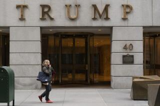 FILE - A woman walks past the Trump Building in New York's financial district, Wednesday, Jan. 13, 2021. Mazars USA LLP, the accounting firm that prepared former President Donald Trump’s annual financial statements, says the documents “should no longer be relied upon” after investigators said they found evidence he and his company regularly misstated the value of assets. (AP Photo/Mark Lennihan, File)