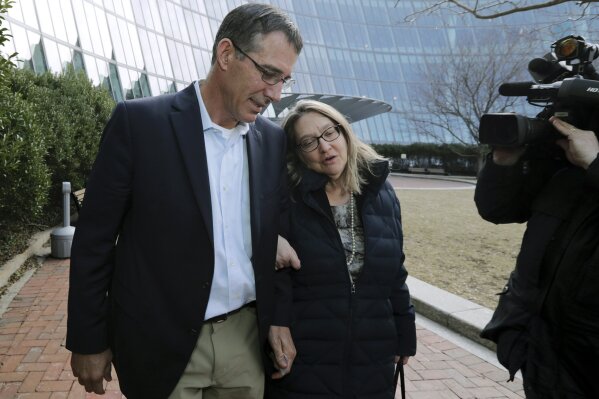 
              Michael Center, left, former Texas tennis coach, departs federal court in Boston with an unidentified woman on Thursday, March 28, 2019, after facing charges in a nationwide college admissions bribery scandal. (AP Photo/Charles Krupa)
            