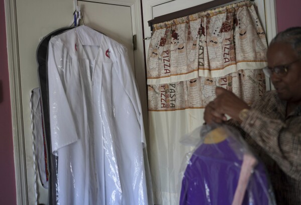 Wendy Owens, a United Methodist Minister and mother of Lama Rod Owens, shows her robes hanging in her home on Saturday, March 30, 2024, in Rome Georgia. (AP Photo/Jessie Wardarski)