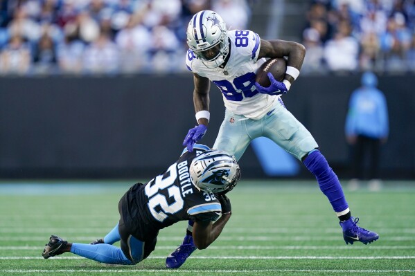 Dallas Cowboys wide receiver CeeDee Lamb is tackled by Carolina Panthers cornerback Dicaprio Bootle during the second half of an NFL football game Sunday, Nov. 19, 2023, in Charlotte, N.C. (AP Photo/Erik Verduzco)