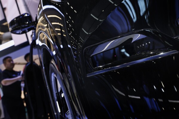 In this photo released by Xinhua News Agency, a new energy vehicle using "LiDAR" intelligent driving equipment are display at the 21st Guangzhou International Automobile Exhibition in Guangzhou, south China's Guangdong Province on Nov. 17, 2023. A Nasdaq-listed Chinese technology company that makes parts for self-driving vehicles is threatening to sue the U.S. government after it was included in a list of companies the Pentagon says have links to the Chinese military. (Liu Dawei/Xinhua via AP)
