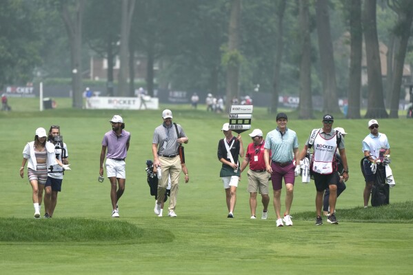 The pro-am team of Erik Van Rooyen and Akshay Bhatia walk up the ninth fairway during a practice round of the Rocket Mortgage Classic golf tournament at Detroit Country Club, Wednesday, June 28, 2023, in Detroit. (AP Photo/Carlos Osorio)