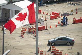 Car cross the border into Canada, in Niagara Falls, Ontario, on Monday, Aug. 9, 2021. American citizens and permanent residents are now allowed to enter Canada for non-essential purposes if they can provide proof that they've been fully vaccinated for at least 14 days. (Eduardo Lima/The Canadian Press via AP)