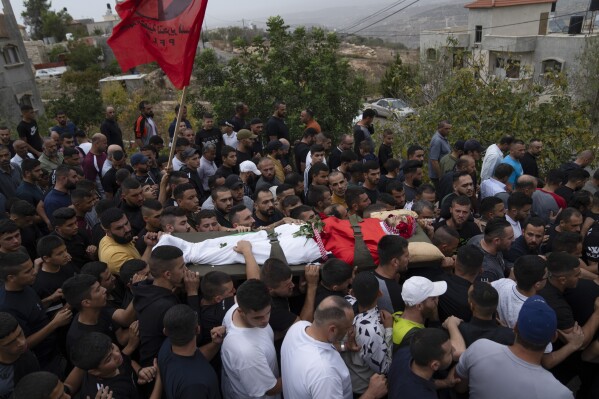 Palestinians carry Nasser Barghouti during his funeral in the West Bank village of Beit Rima, northwest of Ramallah, Sunday, Oct. 29, 2023. Barghouthi was killed during an Israeli army raid in Bait Reema early morning, the Palestinian Ministry of Health said. (AP Photo/Nasser Nasser)