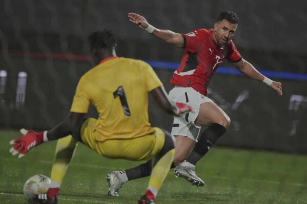 Egypt's Hassan Mahmoud, right, challenges for the ball with Sierra Leone's goalkeeper Sesay during a World Cup 2026 qualifying soccer match at Cairo International Stadium, Egypt, Tuesday, March 25, 2025. (AP Photo/Amr Nabil)