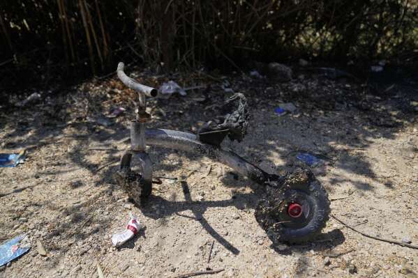 A burnt children bicycle is seen on the Palestinian properties that were under attack by Israeli settlers overnight, leaving several burnt vehicles and damaged homes, residents said, in the West Bank village of Bruqin, near Salfit, Friday, May 23, 2025. (AP Photo/Nasser Nasser)