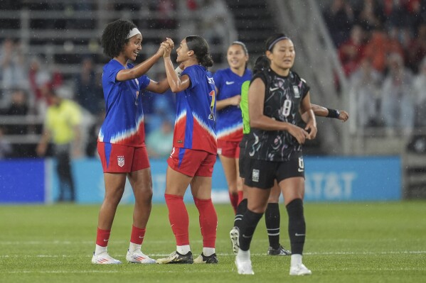 United States midfielder Lily Yohannes, left, and forward Sophia Smith, center, celebrate after the 3-0 win against South Korea of an international friendly soccer match in St. Paul, Minn., Tuesday, June 4, 2024. (AP Photo/Abbie Parr)
