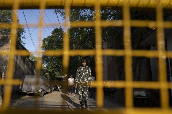 A security person stands guard outside the office of Delhi Police's Special Cell in New Delhi, India, Tuesday, Oct. 3, 2023. Indian police raided the offices of a news website that’s under investigation for allegedly receiving funds from China, as well as the homes of several of its journalists, the latest in a series of investigations into the finances of independent media in India. (AP Photo/Altaf Qadri)