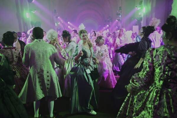 Costumed guests dance at the Great Masked Ball in the Orangerie of the Versailles castle, outside Paris, Sunday, June 22, 2025. (AP Photo/Christophe Ena)