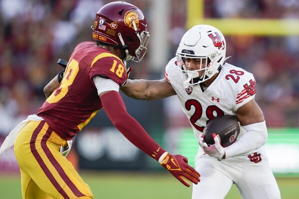 Utah running back Sione Vaki (28) stiff arms Southern California linebacker Eric Gentry (18) during the first half of an NCAA college football game, Saturday, Oct. 21, 2023, in Los Angeles. (AP Photo/Ryan Sun)