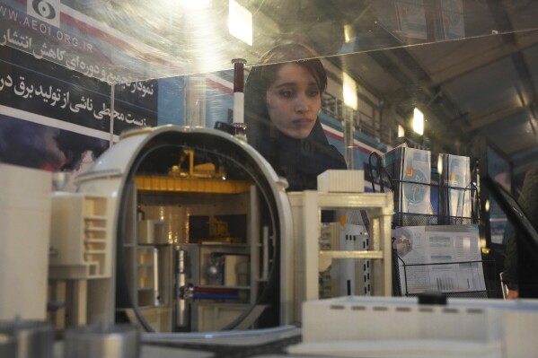 FILE - A student looks at a model of Bushehr nuclear power plant in an exhibition of the country's nuclear achievements, in Tehran, Iran, Wednesday, Feb. 8, 2023. Iran has further increased its total stockpile of uranium, according to a report by the United Nations’ nuclear watchdog seen by The Associated Press on Monday, and continues to bar several of the most experienced inspectors from monitoring its nuclear program. The IAEA report estimated that as of Feb. 10, Iran’s total enriched uranium stockpile was at 5,525.5 kilograms, an increase of 1038.7 kilograms since the last quarterly report in November 2023. (AP Photo/Vahid Salemi, File)