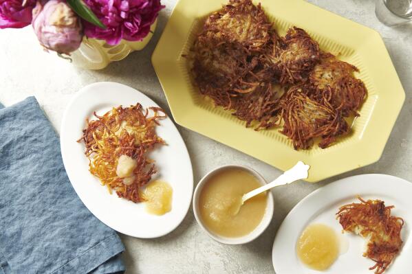 Plates of potato pancakes, or latkes, are displayed in New York in August 2020. Latkes are the food most traditionally associated with Hanukkah. There are all kinds of modern variations using other vegetables and other toppings. (Cheyenne M. Cohen via AP)