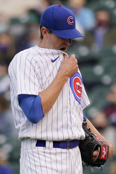 Chicago Cubs starting pitcher Kyle Hendricks wipes his face after Atlanta Braves' Ehire Adrianza hit a solo home run during the first inning of a baseball game in Chicago, Sunday, April 18, 2021. (AP Photo/Nam Y. Huh)