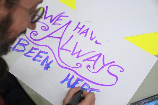 Gabriel Faith, of Newark, N.J., makes a sign during a pre-rally for the National Trans Visibility March, at the Human Rights Campaign, before marching to join the World Pride Rally on the National Mall, Sunday, June 8, 2025, in Washington. (AP Photo/Jacquelyn Martin)