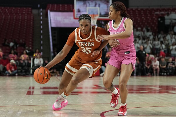 Texas forward Madison Booker (35) is defended by Houston guard N'Yah Boyd during the first half of an NCAA college basketball game Wednesday, Feb. 14, 2024, in Houston. (AP Photo/Kevin M. Cox)