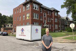 Kristen Bigogno stands in front of her St. Louis apartment on July 30, 2021. A storage trailer sits behind her. Bigogno expects to be evicted, along with her two teenage sons, soon after the federal moratorium ends after Saturday. She says they have no place to go and may face homelessness.(AP Photo by Jim Salter)