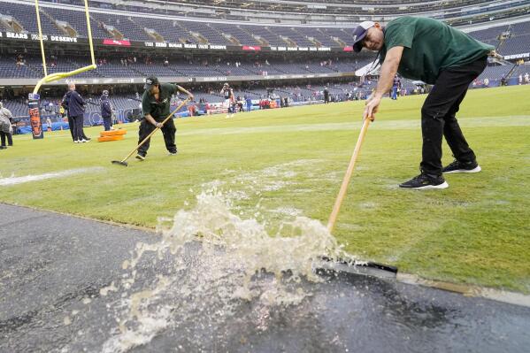 Workers remove water from Soldier Field before an NFL football game between the Chicago Bears and the San Francisco 49ers Sunday, Sept. 11, 2022, in Chicago. (AP Photo/Charles Rex Arbogast)