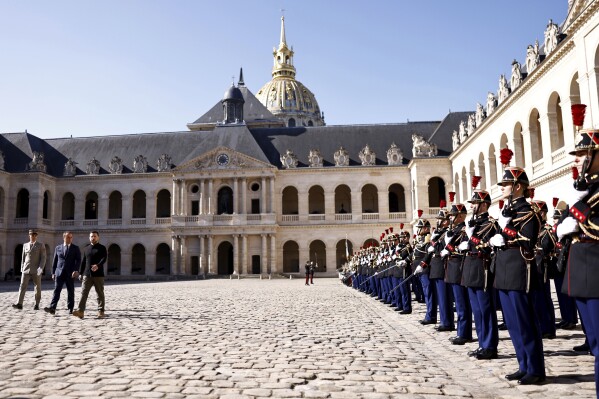 Ukrainian President Volodymyr Zelenskyy (third from left), French Defense Minister Sebastien Lecornu (second from left) and Paris military governor and army corps general Christophe Abad attend a military honors ceremony in Paris, Friday, June 7, 2024. (Samir Al Doumi, Pool via The Associated Press)