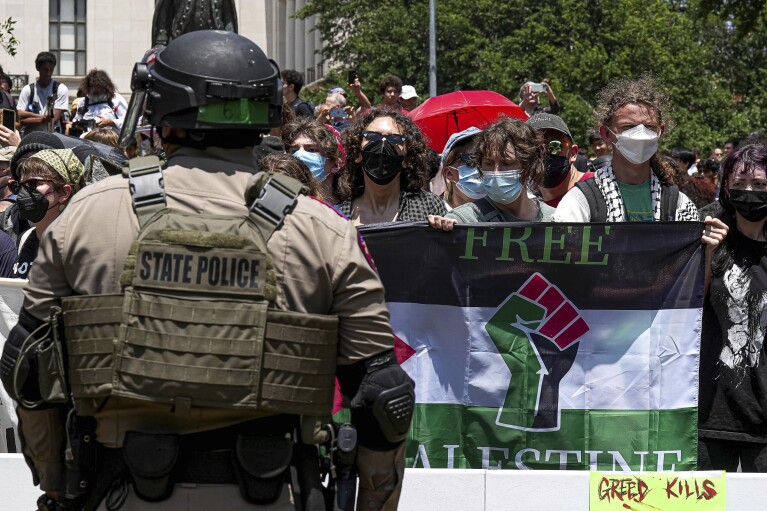 Pro-Palestinian protesters stand with linked arms surrounded by Texas state troopers and police at an encampment at University of Texas in Austin, Texas, Monday, April 29, 2024. (Aaron E. Martinez/Austin American-Statesman via AP)
