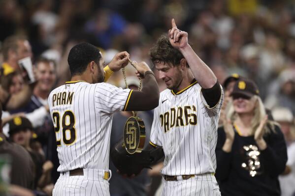 San Diego Padres' Manny Machado (13) puts the swag chain on Ha-Seong Kim  (7) after he hit a solo home run during the fifth inning of a baseball game  against Los Angeles