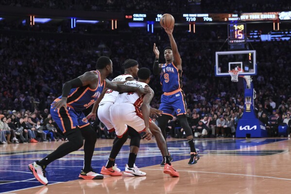 New York Knicks guard RJ Barrett (9) passes the ball to forward Julius Randle (30) as Miami Heat forward Jimmy Butler (22) and forward Haywood Highsmith (24) defend during the second half of an NBA basketball In-Season Tournament game, Friday, Nov. 24, 2023, in New York. (AP Photo/John Jones)