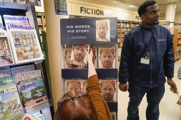 Copies of the new book by Prince Harry called "Spare" are placed on a shelf by a member of staff of a book store during a midnight opening in London, Tuesday, Jan. 10, 2023. Prince Harry's memoir “Spare” arrives in bookstores on Tuesday, providing a varied portrait of the Duke of Sussex and the royal family. (AP Photo/Alberto Pezzali)