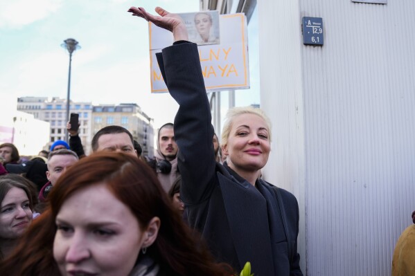 Yulia Navalnaya, widow of Alexey Navalny, waves as she stands in a queue with other voters near the polling station at the Russian embassy in Berlin, after noon local time, on Sunday, March 17, 2024. The Russian opposition called on people to head to polling stations at noon on Sunday in protest as voting takes place on the last day of a presidential election that was all but certain to extend President Vladimir Putin's rule after he clamped down on dissent. AP can't confirm that all the voters seen at the polling station at noon were taking part in the opposition protest. (AP Photo/Ebrahim Noroozi)