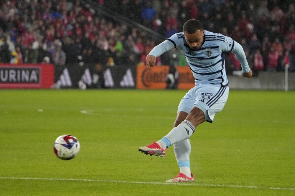 Sporting Kansas City defender Logan Ndenbe scores a goal during the first half of an MLS playoff soccer match against St. Louis City Sunday, Oct. 29, 2023, in St. Louis. (AP Photo/Jeff Roberson)