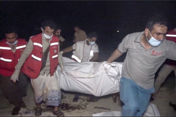This photo taken from video released by Al Masirah TV channel shows medics carrying a dead person after U.S. airstrikes targeted the Ras Isa oil port held by Yemen's Houthi rebels in Hodeida, Yemen, Friday, April 18, 2025.( Al Masirah TV via AP)