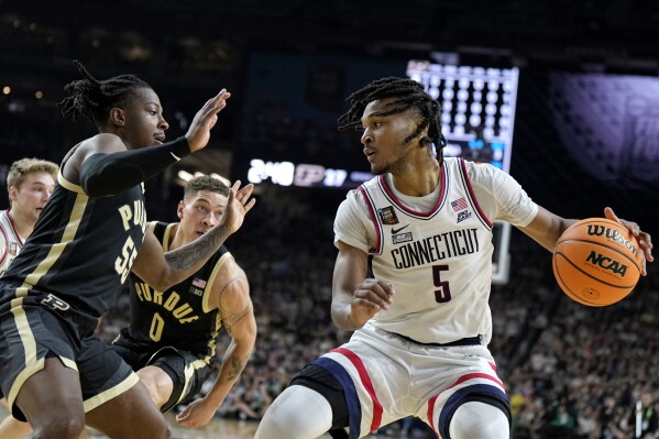 UConn guard Stephon Castle (5) drives as Purdue guard Lance Jones defends during the first half of the NCAA college Final Four championship basketball game, Monday, April 8, 2024, in Glendale, Ariz. (AP Photo/Brynn Anderson)