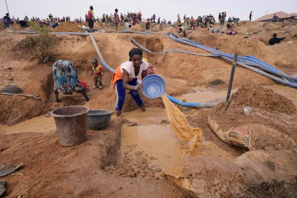 A woman works at an Illegal tin mining site in Jos, Nigeria, Wednesday, April 3, 2024. The recent arrests come as Nigeria seeks to regulate mining of critical minerals, curb illegal activity and better benefit from its mineral resources. (AP Photo/Sunday Alamba)