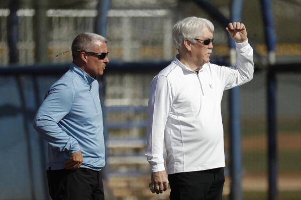 FILE - Kansas City Royals general manager Dayton Moore, left, and owner John Sherman watch a drill during spring training baseball practice Wednesday, Feb. 19, 2020, in Surprise, Ariz. The Kansas City Royals, Wednesday, Sept. 21, 2022, fired longtime general manager Dayton Moore. Royals owner John Sherman, who had retained Moore after acquiring the club from David Glass in 2019, announced the decision in a news conference that Moore attended at Kauffman Stadium on Wednesday. (AP Photo/Charlie Riedel, File)