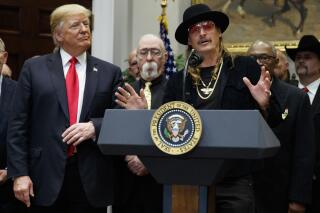 President Donald Trump looks on as musician Kid Rock speaks during a signing ceremony for the "Orrin G. Hatch-Bob Goodlatte Music Modernization Act," in the Roosevelt Room of the White House, Thursday, Oct. 11, 2018, in Washington. (AP Photo/Evan Vucci)