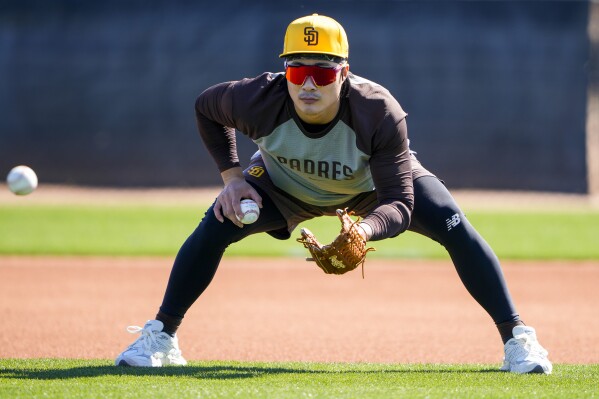 San Diego Padres second baseman Ha-Seong Kim works on fielding drills during spring training baseball workouts Tuesday, Feb. 13, 2024, in Peoria, Ariz. (AP Photo/Lindsey Wasson)