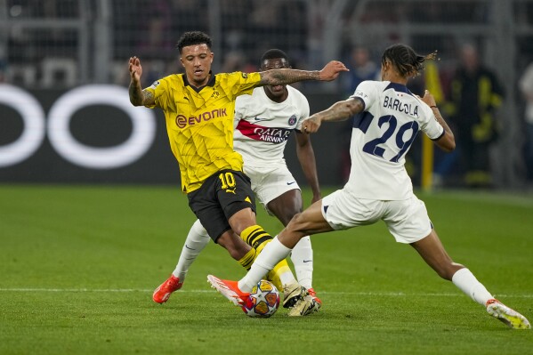 PSG's Bradley Barcola, right, and Dortmund's Jadon Sancho compete for the ball during the Champions League semifinal first leg soccer match between Borussia Dortmund and Paris Saint-Germain at the Signal-Iduna Park in Dortmund, Germany, Wednesday, May 1, 2024. (AP Photo/Martin Meissner)