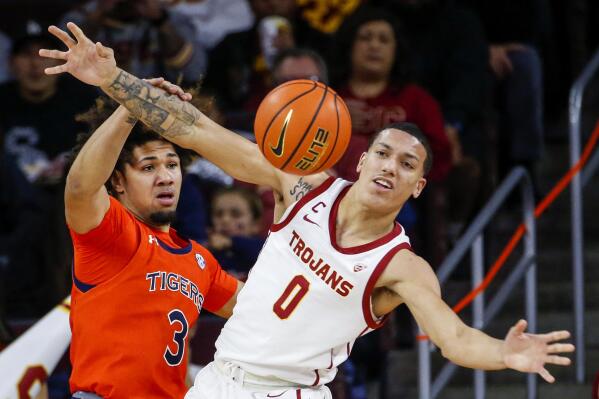 Southern California guard Kobe Johnson, left, and Auburn guard Tre Donaldson fight for the ball during the first half of an NCAA college basketball game, Sunday, Dec. 18, 2022, in Los Angeles. (AP Photo/Ringo H.W. Chiu)