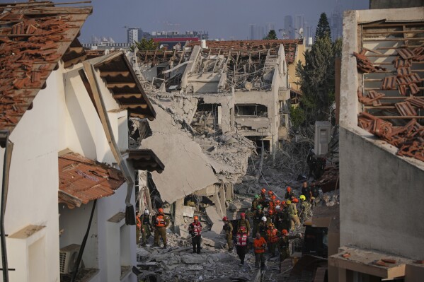 Israeli security forces inspect destroyed houses that were struck by a missile fired from Iran, in Rishon Lezion, Israel on Saturday, June 14, 2025. (AP Photo/Ohad Zwigenberg)