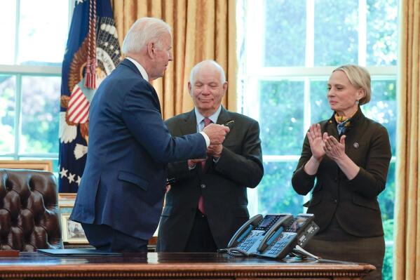 President Joe Biden hands a pen to Rep. Victoria Spartz, R-Ind., right, after signing the Ukraine Democracy Defense Lend-Lease Act of 2022 in the Oval Office of the White House, Monday, May 9, 2022, in Washington. Sen. Ben Cardin, D-Md., applauds at center. (AP Photo/Manuel Balce Ceneta)