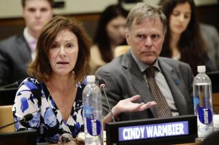 FILE- In this May 3, 2018 file photo, Fred Warmbier, right, listens as his wife Cindy Warmbier, speaks of their son Otto Warmbier, during a meeting at the United Nations headquarters. A federal judge has ruled that the parents of Otto Warmbier, a U.S. student who died after being taken hostage by North Korea and released by the country in a coma in 2017, should receive about $240,000 seized from a North Korean bank account. The amount would be a partial payment toward the more than $501 million Fred and Cindy Warmbier of Wyoming, Ohio, were awarded in 2018 by a federal judge in Washington, D.C. (AP Photo/Frank Franklin II)