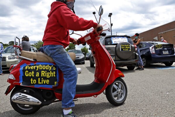 A caravan of cars and bikes organizes in the parking lot of a Shop & Save in downtown Pittsburgh as part of the Pennsylvania Poor People's Campaign: National Call for Moral Revival, Sunday, June 14, 2020. The caravan circled various governmental offices in Pittsburgh. (AP Photo/Gene J. Puskar)