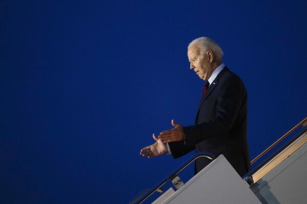 President Joe Biden reacts to people waiting for him at the bottom of the steps of Air Force One as he arrives at Stansted Airport in Stansted, England, Sunday, July 9, 2023. (AP Photo/Susan Walsh)