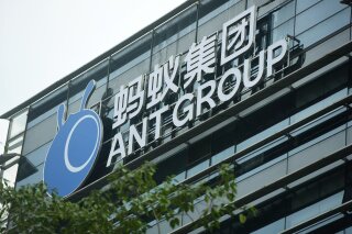 FILE - In this Oct. 26, 2020, file photo, a view of the signage of Ant Group is seen at the headquarters compound of the fintech giant in Hangzhou in eastern China's Zhejiang province. Chinese regulators have ordered Alibaba Group Holding’s financial affiliate Ant Group to become a financial holding company that could be regulated more stringently and cease anti-competitive behavior, months after its record initial public offering was halted.(Chinatopix Via AP, File)