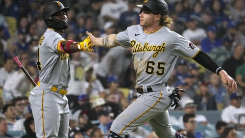 CORRECTS THAT SUWINSKI SCORED ON A SINGLE BY JARED TRIOLO, INSTEAD OF A DOUBLE BY JOSH PALACIOS - Pittsburgh Pirates' Jack Suwinski, right, is congratulated by Rodolfo Castro after scoring on a single by Jared Triolo during the ninth inning of a baseball game against the Los Angeles Dodgers on Tuesday, July 4, 2023, in Los Angeles. (AP Photo/Mark J. Terrill)