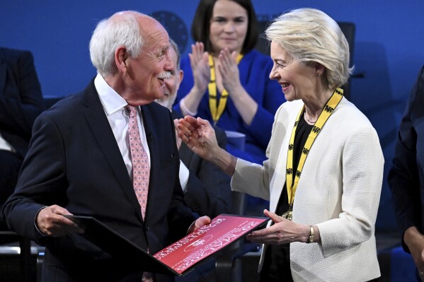 European Commission President Ursula von der Leyen, right, receives the Charlemagne Prize by Juergen Linden, left, Chairman of the Charlemagne Prize Board of Directors, in Aachen, Germany, Thursday, May 29, 2025. (Federico Gambarini/DPA via AP, Pool)