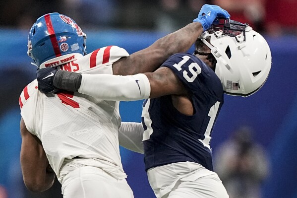 Mississippi running back Quinshon Judkins (4) runs into Penn State defensive end Jameial Lyons (19) during the second half of the Peach Bowl NCAA college football game, Saturday, Dec. 30, 2023, in Atlanta. (AP Photo/Brynn Anderson)