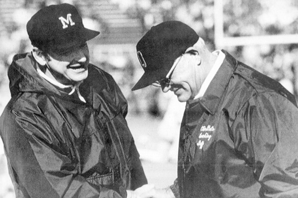 FILE - Michigan coach Bo Schembechler, left, meets with Ohio State coach Woody Hayes at an NCAA college football game. Woody and Bo were kindred spirits as they clashed during the 1970s in what became known as the 10-year Year War between Ohio State and Michigan. The mutual respect that has been a pillar of what is arguably college football’s greatest rivalry appears to be lacking these days — even among the coaches.(AP Photo/File)