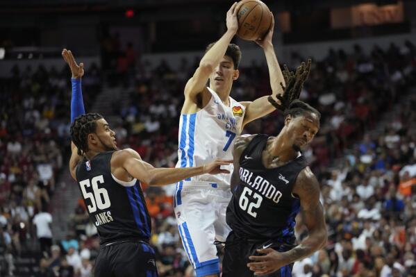 Oklahoma City Thunder's Chet Holmgren passes around Orlando Magic's Justin James, left, and Orlando Magic's Emanuel Terry, right, during the first half an NBA summer league basketball game Monday, July 11, 2022, in Las Vegas. (AP Photo/John Locher)