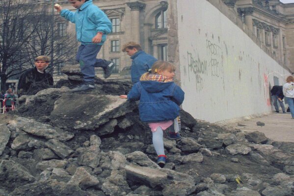 Berlin children play on the remains of the Berlin Wall near West Berlin's Reichstag building, Feb. 20, 1990, where East German border troops began tearing down the wall.  (AP Photo/Jockel Finck)